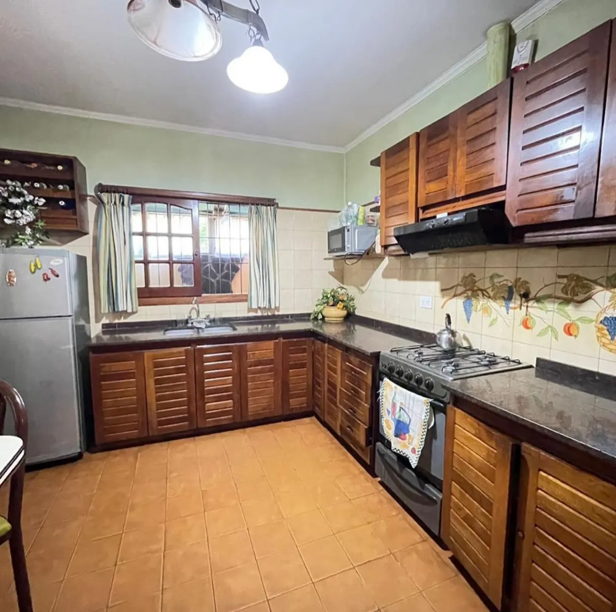 Cocina equipada con mesadas, alacenas y una ventana