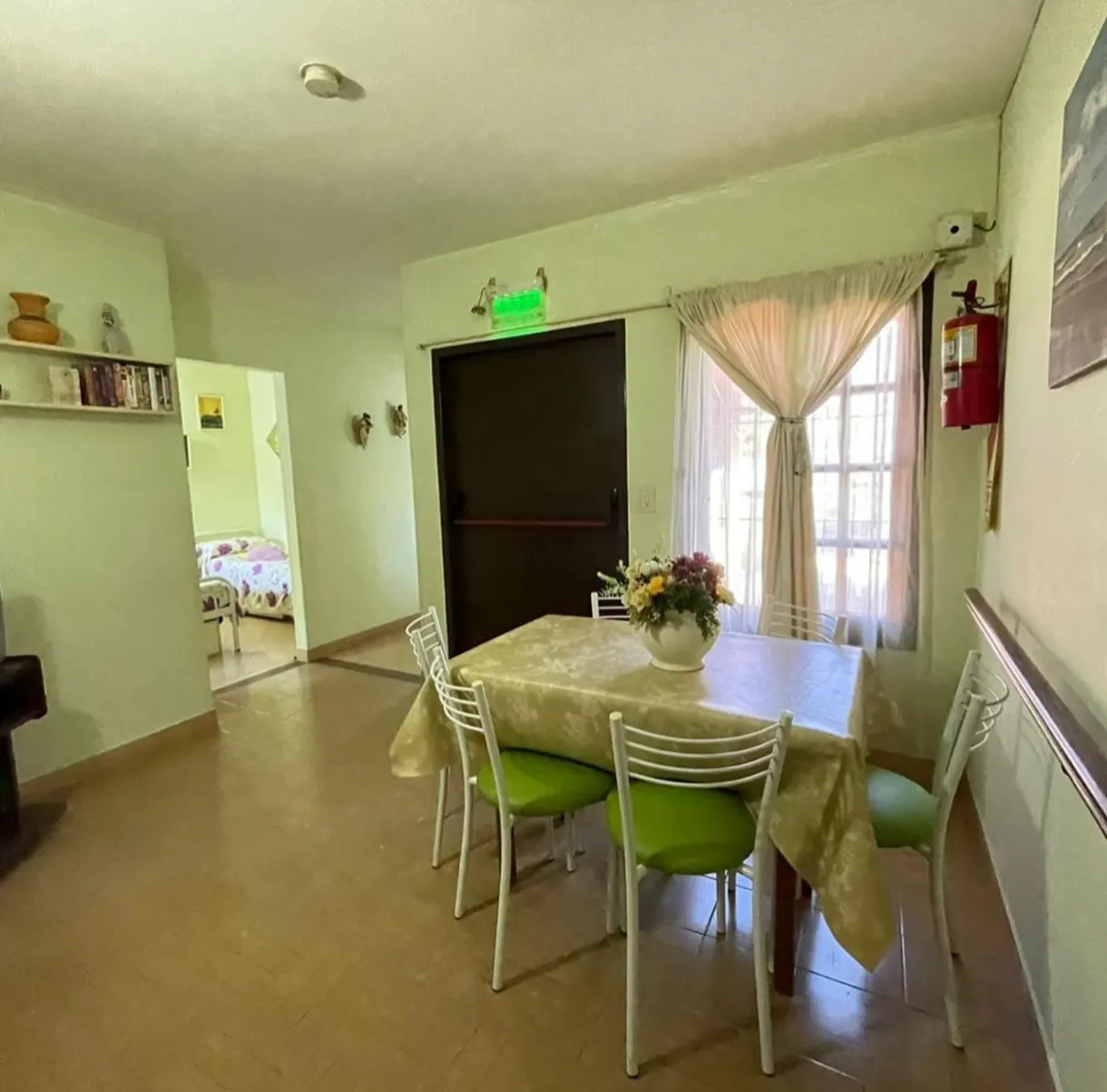 Espacio común con mesa y sillas junto a una ventana